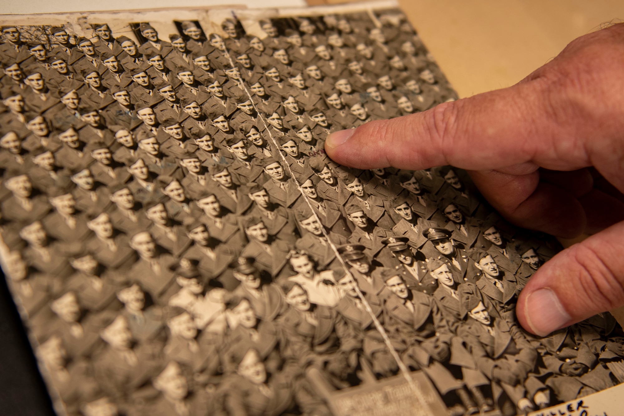 A photo of the Wing historian pointing at a photograph.