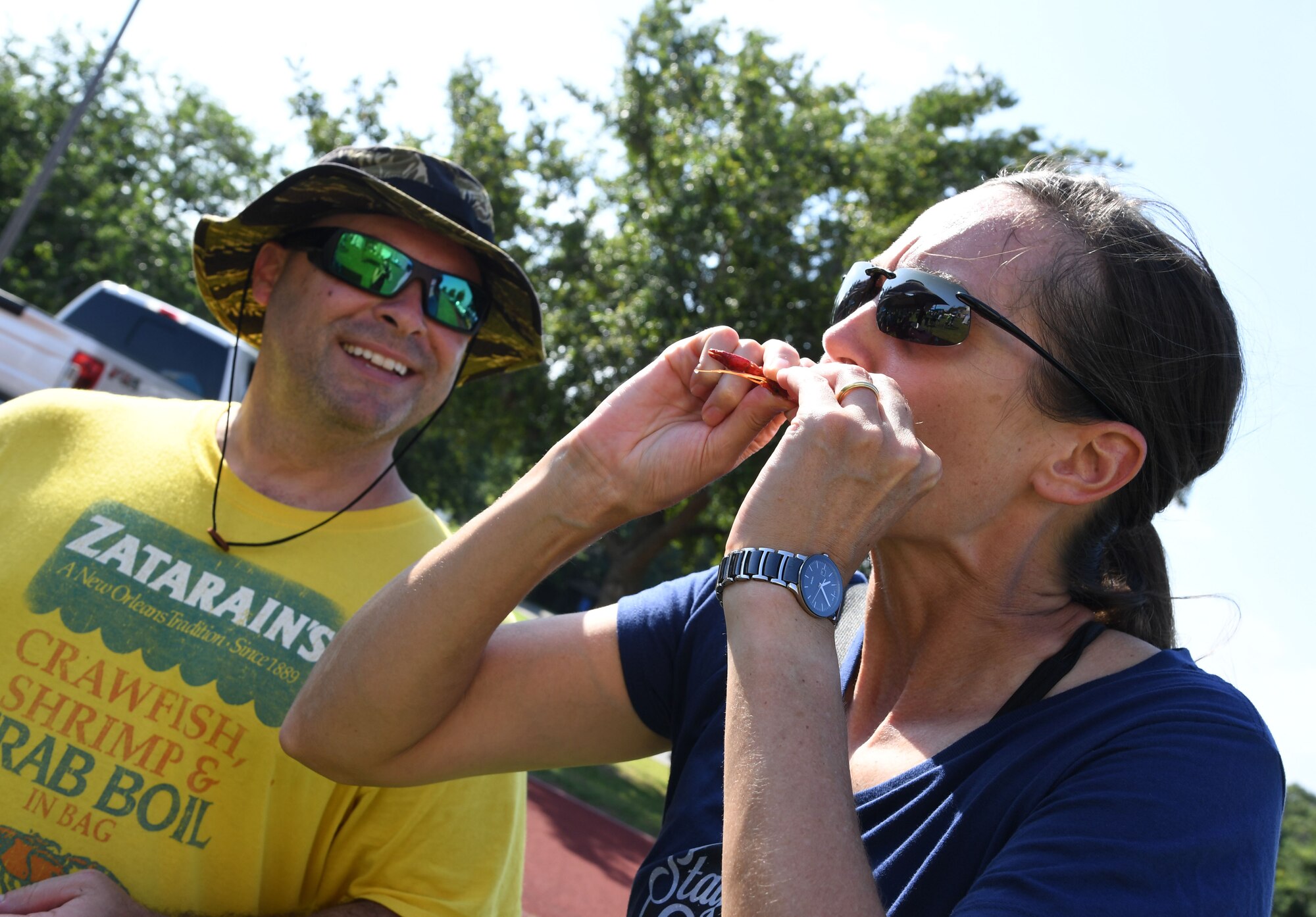 U.S. Air Force Col. Heather Blackwell, 81st Training Wing commander, samples a crawfish while Gary Guidry, Second Air Force curriculum developer, watches her during the 9th Annual Crawfish Cook-Off at the Bay Breeze Event Center at Keesler Air Force Base, Mississippi, June 11, 2021. Twelve teams competed in the event and more than 800 pounds of crawfish were distributed. (U.S. Air Force photo by Kemberly Groue)