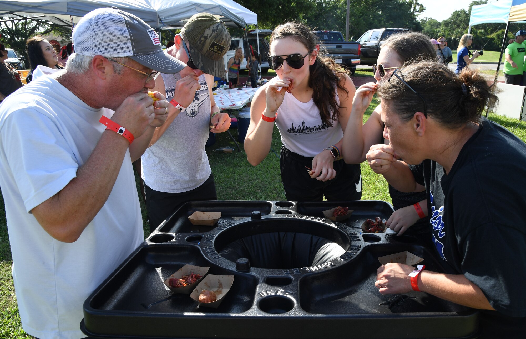 Keesler personnel sample boiled crawfish and the "fixins" during the 9th Annual Crawfish Cook-Off at the Bay Breeze Event Center at Keesler Air Force Base, Mississippi, June 11, 2021. Twelve teams competed in the event and more than 800 pounds of crawfish were distributed. (U.S. Air Force photo by Kemberly Groue)