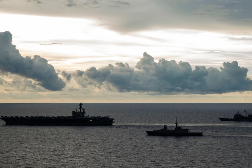 Three ships transit a body of water.