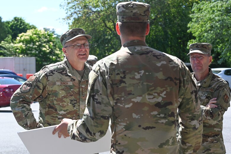 Gen. Arnold W. Bunch, Jr., Air Force Materiel Command commander, listens to Capt. Scott Coberly, 66th Medical Squadron pharmacist, during a visit to the clinic at Hanscom Air Force Base, Mass., June 16, while Chief Master Sgt. Stanley C. Cadell, AFMC command chief, looks on. Coberly headed the Hanscom clinic’s vaccination process throughout COVID-19.  (U.S. Air Force photo by Todd Maki)