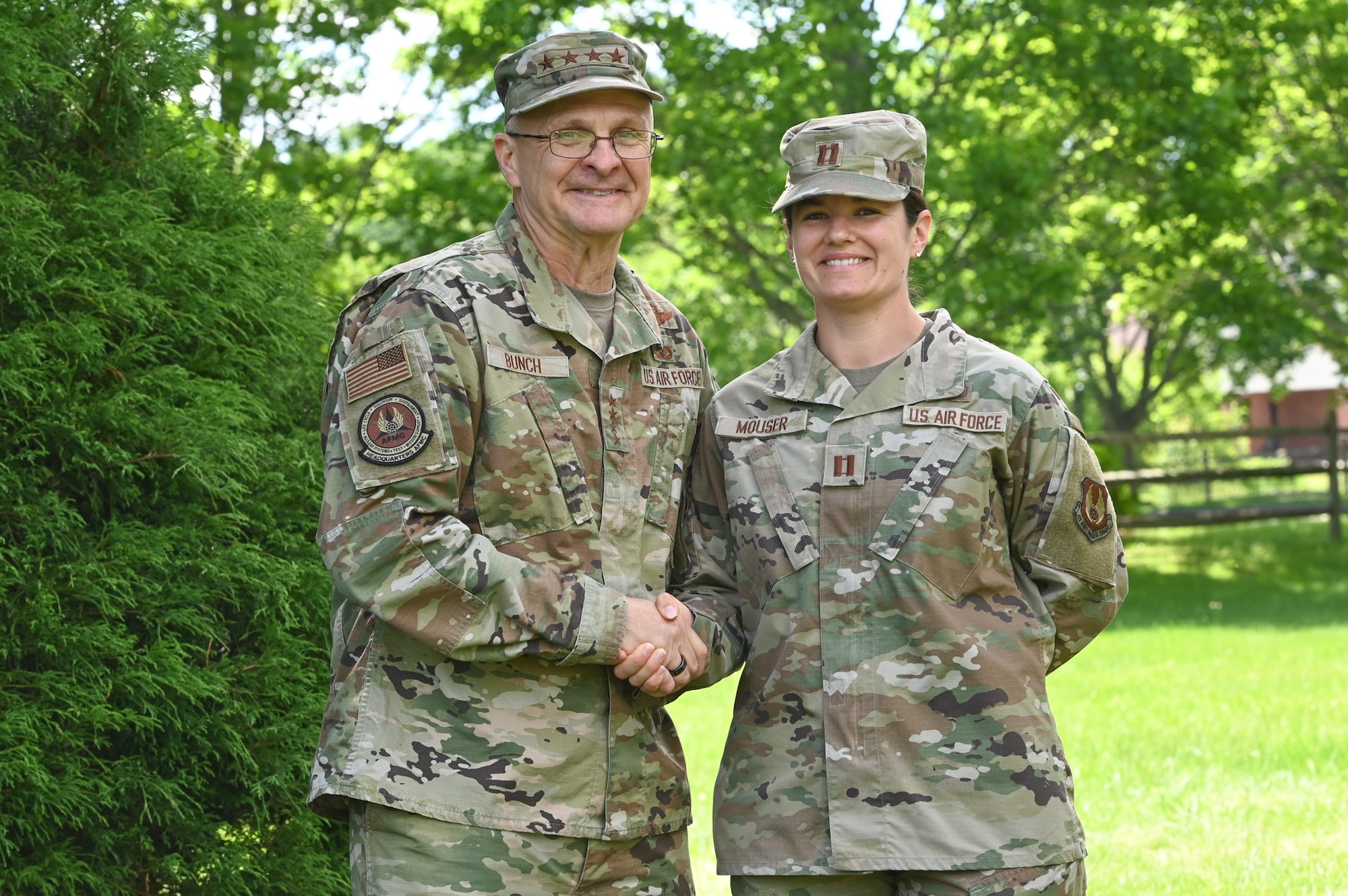 Gen. Arnold W. Bunch, Jr., Air Force Materiel Command commander, coins Capt. Jenifer Mouser, 66th Medical Squadron officer in charge of Laboratory and Radiology, during a visit to the clinic at Hanscom Air Force Base, Mass., June 16. Bunch presented his coin to Mouser and Tech. Sgt. Joshua Anderson, noncommissioned officer in charge of Public Health, during the MDS visit. (U.S. Air Force photo by Todd Maki)