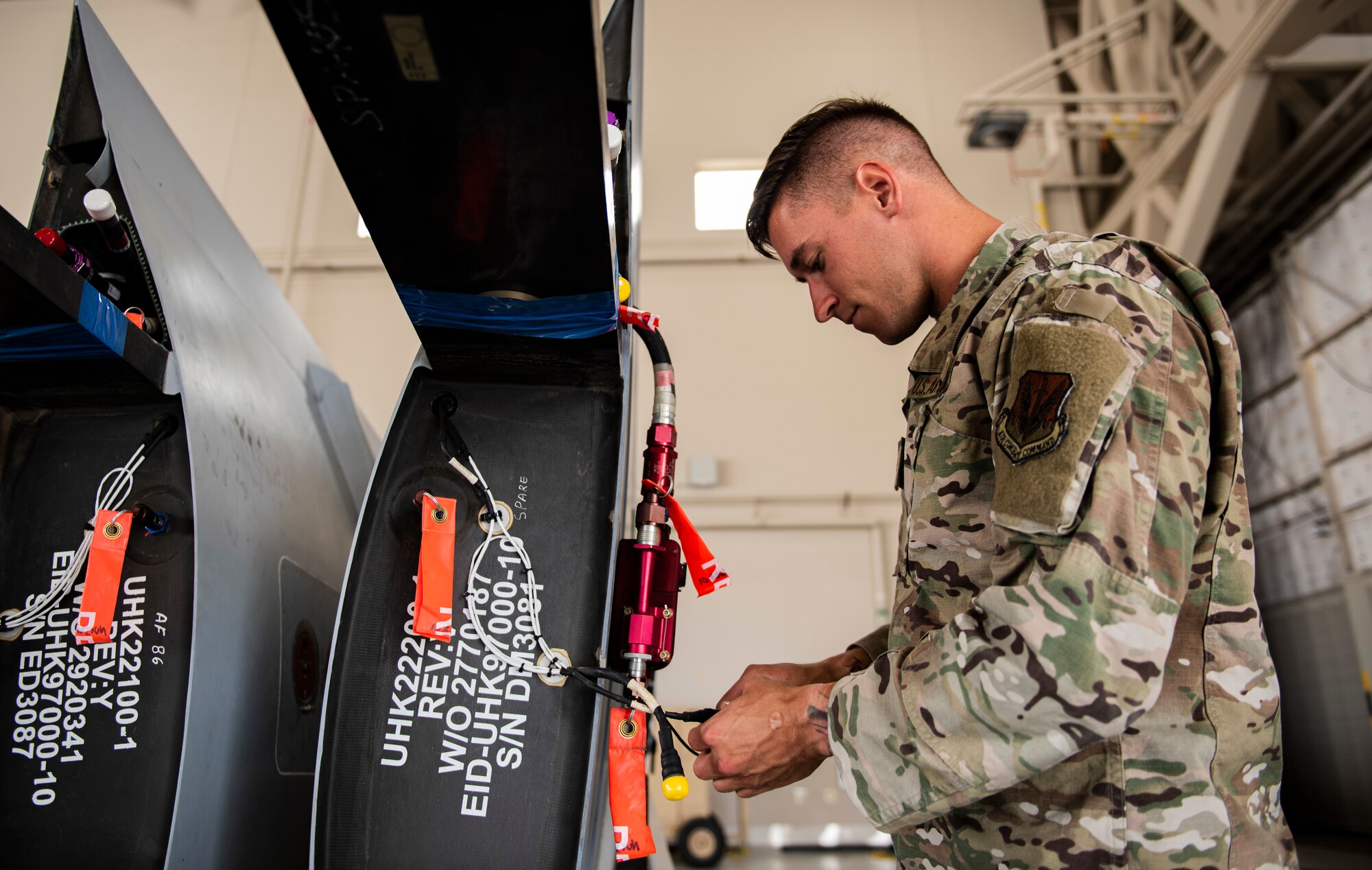 Senior Airman Levi inspects parts of a detached wing from an MQ-9 Reaper.
