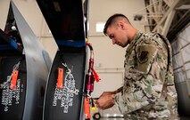 Senior Airman Levi inspects parts of a detached wing from an MQ-9 Reaper.
