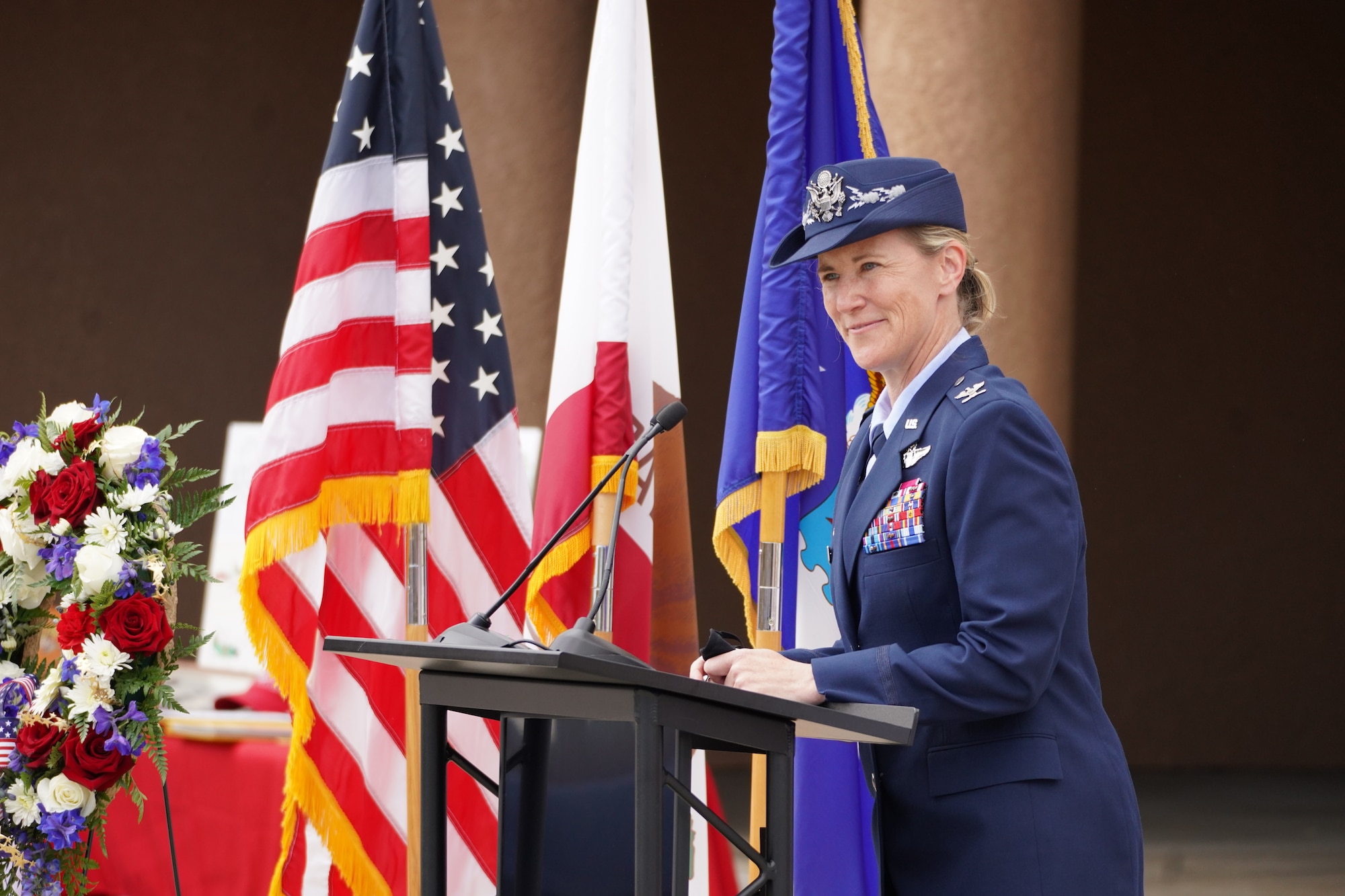 The commander of the 146th Airlift Wing speaks to a crowd at a memorial service.