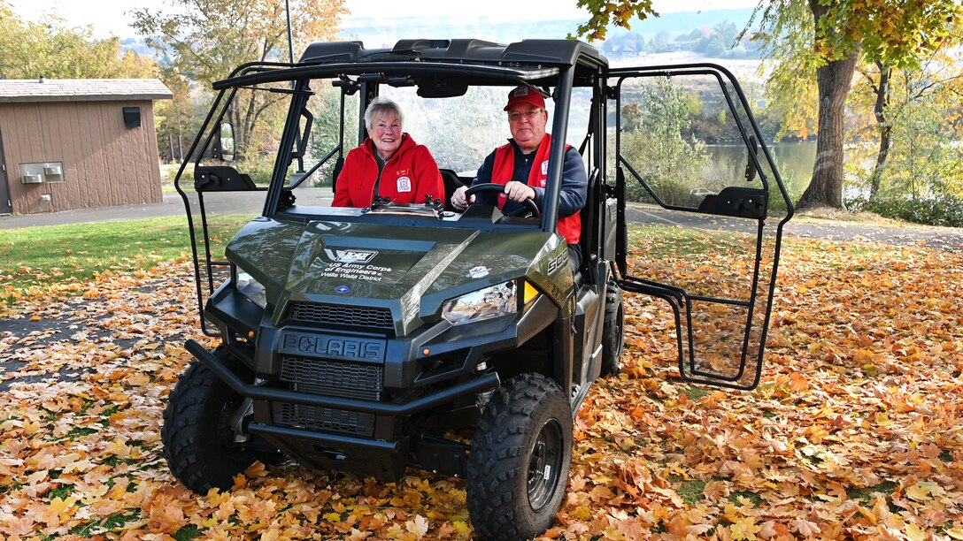 Shirley and John Houser, former camp host volunteers at Swallows Park in Clarkston, sitting in a utility vehicle.