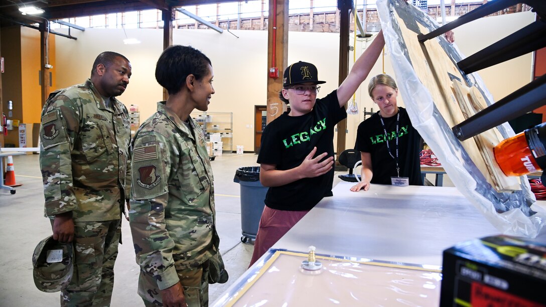Connor Robinson, center left, and Jaida Jones, LEGACY program students, show Col. Jenice Carrol, 75th Air Base Wing commader, and Chief Master Sgt. Raymond Riley, 75th Air Base Wing command chief, a hoverboard made by students during a summer camp in Clearfield, Utah, June 11, 2021. The Leadership Experience Growing Apprenticeships Commited to Youth, or LECAGY program, provides a STEM pipeline that starts with students at age 11 and keeps them in the program until college graduation. (U.S. Air Force photo by R. Nial Bradshaw)
