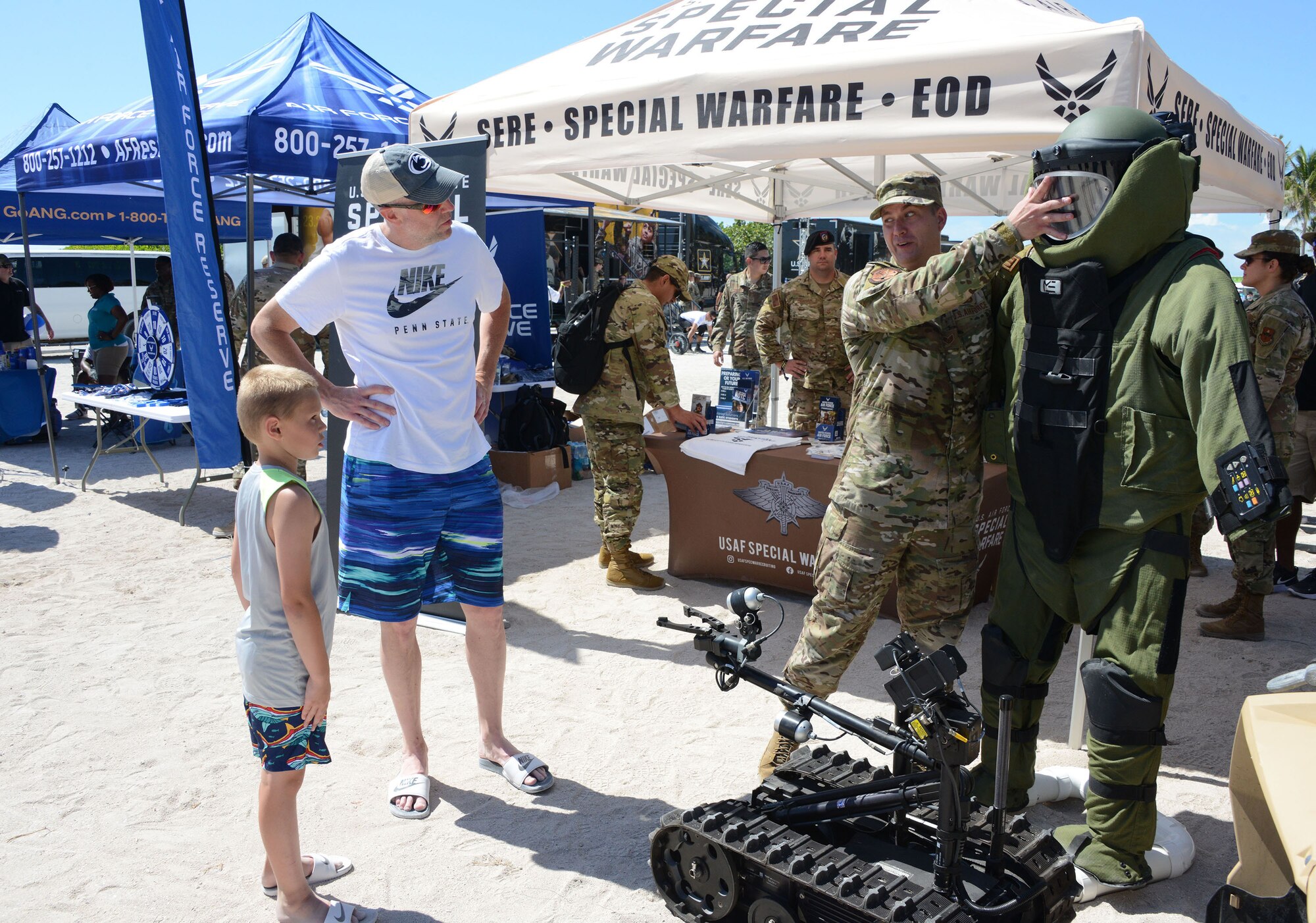 Staff Sgt. Jonathan Stapleton, 330th Recruiting Squadron special warfare recruiter and explosive ordinance technician, explains the EOD bomb suit to a young man and his father at the Miami Beach Air Show, May 28, 2021.