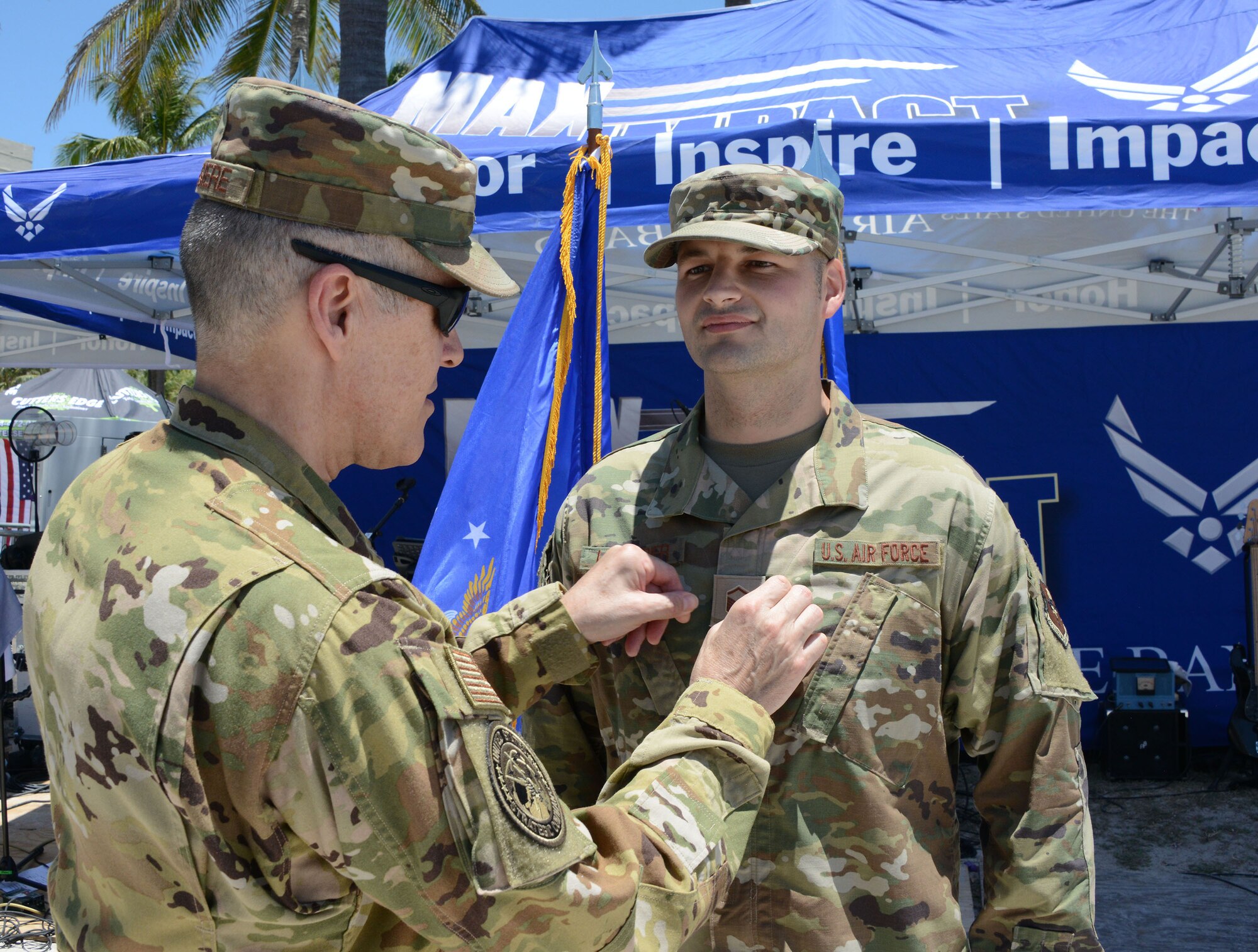 Lt. Gen. Thomas Bussiere, U.S. Strategic Command deputy commander, pins master sergeant rank on Doryan Leterrier, 333rd Recruiting Squadron Enlisted Accessions recruiter, during a promotion ceremony on the beach at the Miami Beach Air Show, May 28, 2021.