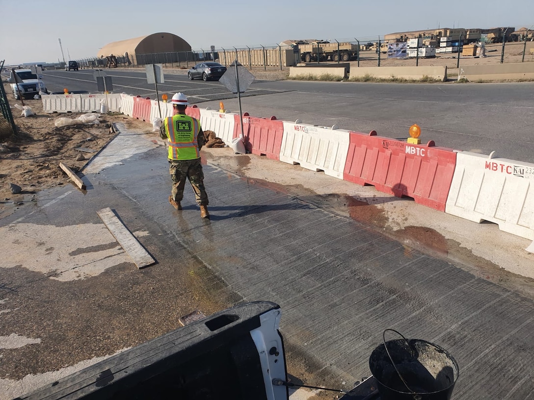 Major Derek Sentinella, a project manager with the U.S. Army Corps of Engineers Transatlantic Middle East District inspects new concrete over a road connection for four lines connecting to a 20 megawatt substation on Camp Arifjan in Kuwait