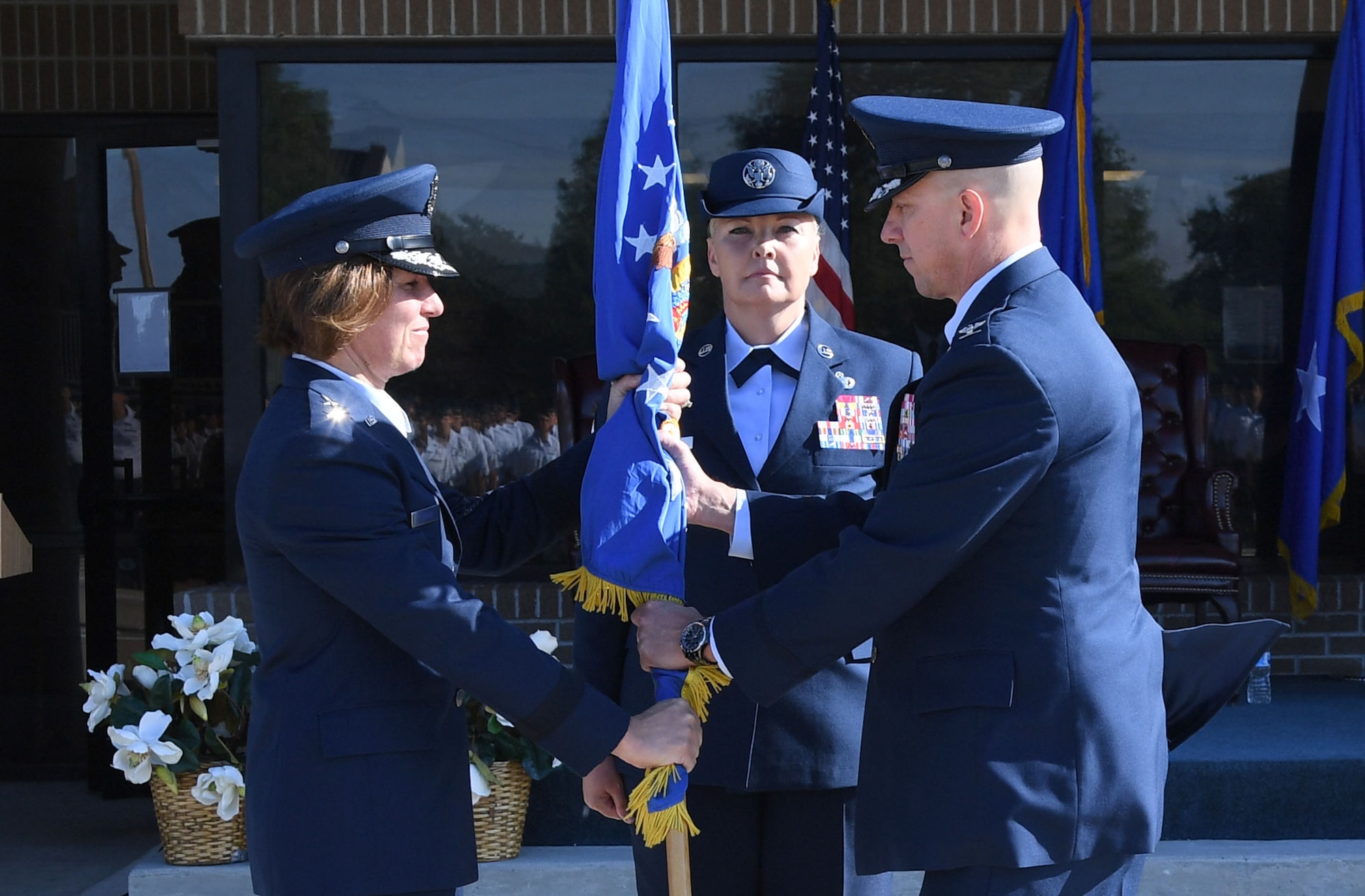 U.S. Air Force Maj. Gen. Andrea Tullos, Second Air Force commander, passes the guidon to Col. William Hunter, 81st Training Wing commander, during a change of command ceremony on the Levitow Training Support Facility drill pad at Keesler Air Force Base, Mississippi, June 17, 2021. The ceremony is a symbol of command being exchanged from one commander to the next. Hunter assumed command of the 81st TRW from Col. Heather Blackwell. (U.S. Air Force photo by Kemberly Groue)