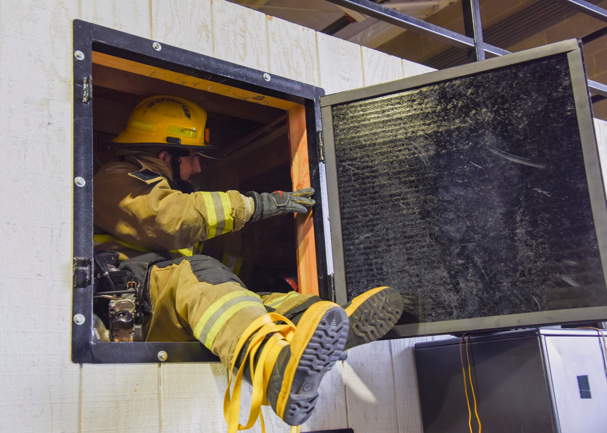A firefighter completes the confined space trainer exercise.