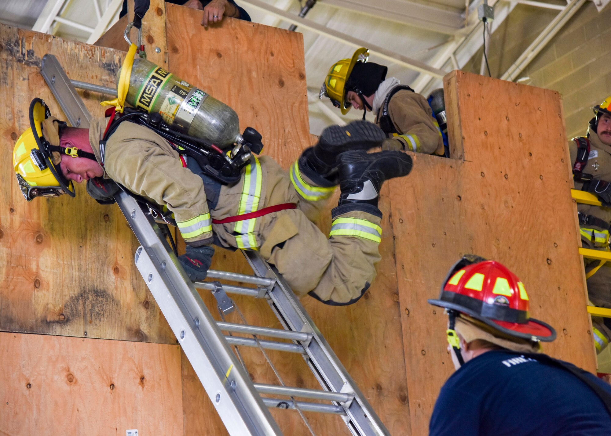 Firefighters practice a ladder bail-out exercise.