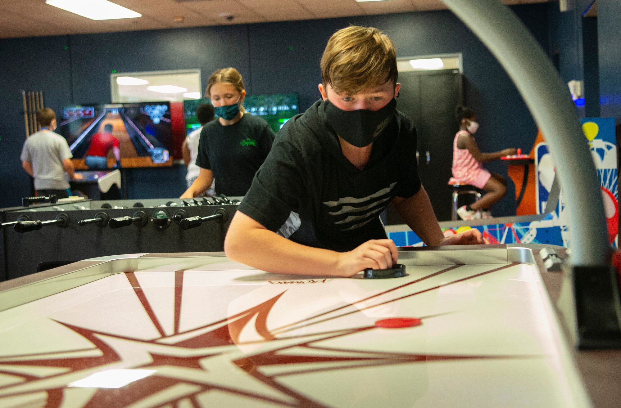 James Smith, 14, plays air hockey as Evelyn Wilbern, 12, checks out the foosball table behind him June 10, 2021, in the Prairies Youth Center’s new game room. The venue, which is having its grand opening June 18, features free arcade games. (U.S. Air Force photo by R.J. Oriez)