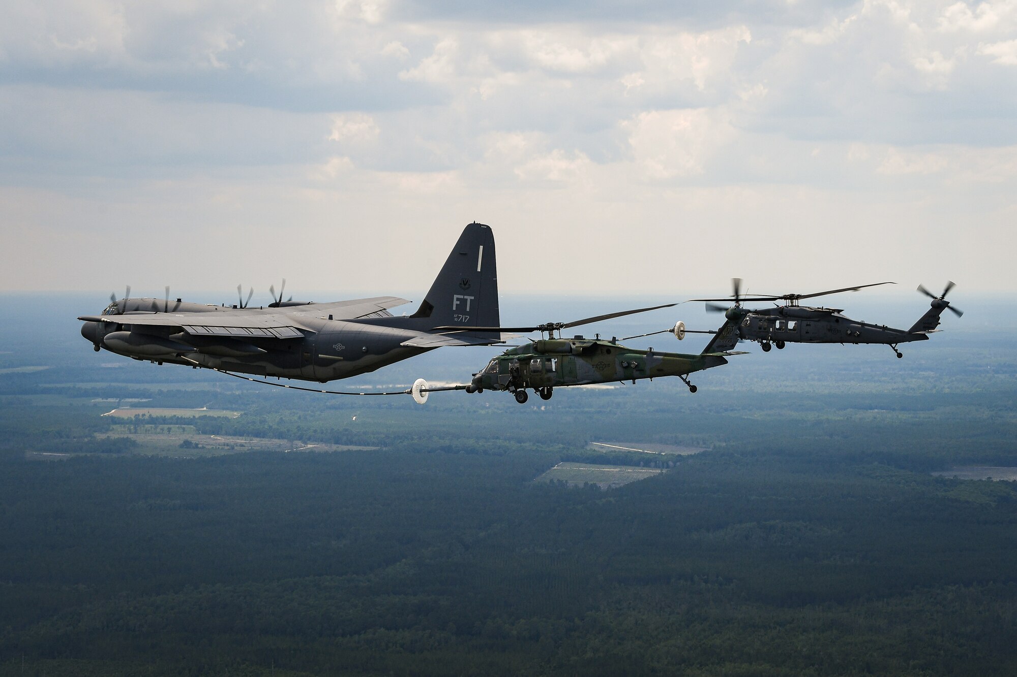 A helicopter receives fuel from a C-130