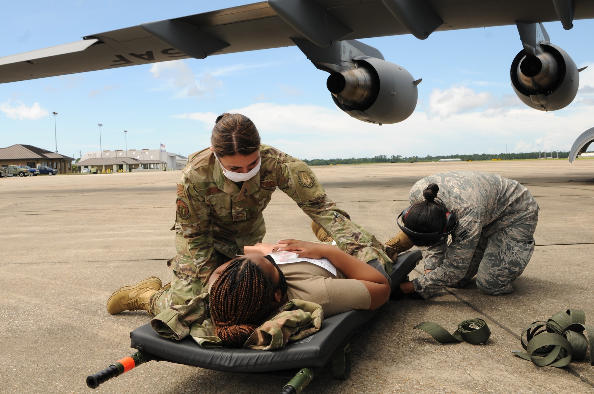 Airmen 1st Class Diana Nunez, a health services management specialists, and Senior Airmen Diana Nguyen, a radio frequency transmission specialist, assigned to the 36th Aeromedical Evacuation Squadron secure a patient to a litter during a training exercise at the Combat Readiness and Training Center in Gulfport, Mississippi, July 20, 2020. The exercise simulated care with both live patients and medical mannequins. (U.S. Air National Guard photo by 2nd Lt. Kiara N. Spann)