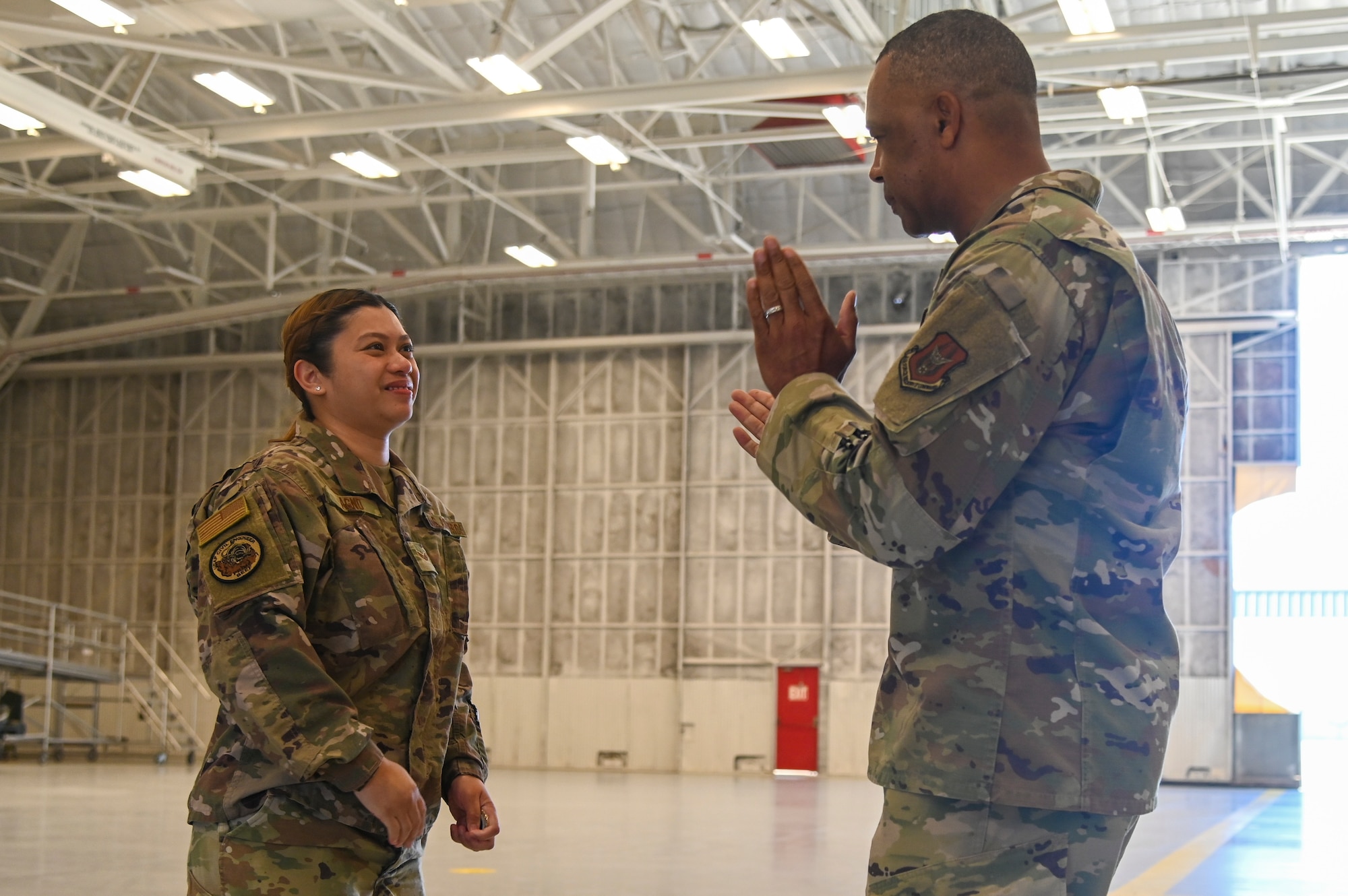 Chief Master Sgt. Timothy C. White Jr., command chief master sergeant, Air Force Reserve Command, Robins Air Force Base, Georgia, applauds Senior Airman Anna Agno from the 940th Civil Engineer Squadron, Beale AFB, during an E-4 and Below meeting June 13, 2021, at Beale AFB, California.