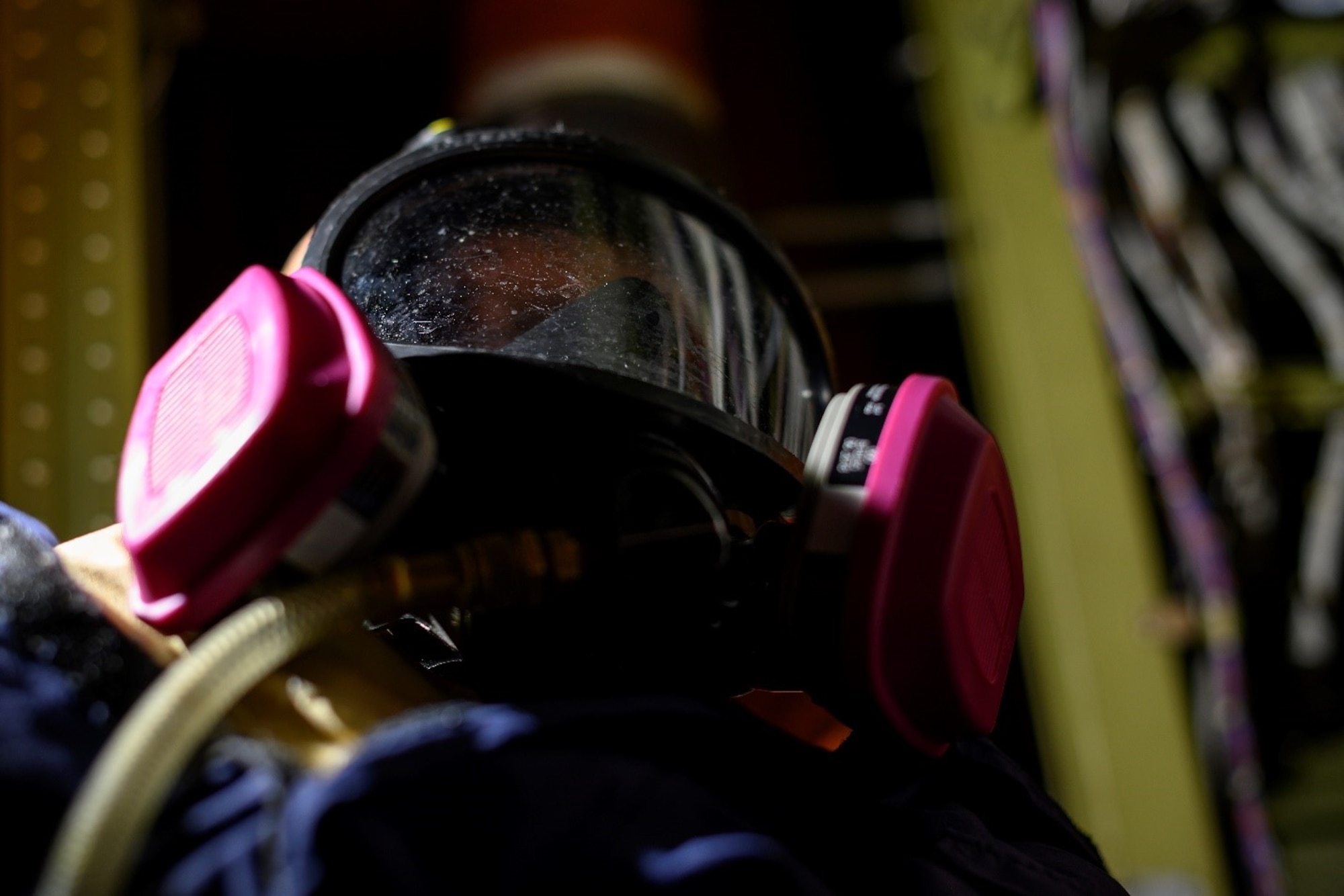 A training dummy in a respirator sits in a compartment of an aircraft