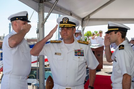Rear Adm. Craig Clapperton, Commander, Carrier Strike Group (CSG) 12, salutes the side-boys as he is welcomed to the CSG-12 Change of Command
