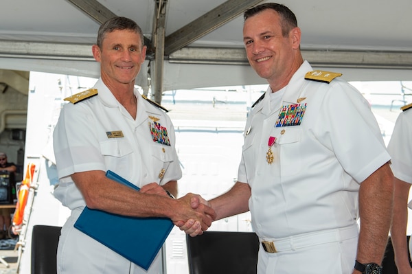 Vice Adm. Andrew Lewis, Commander, U.S. 2nd Fleet, presents Rear Adm. Craig Clapperton, Commander, Carrier Strike Group (CSG) 12,