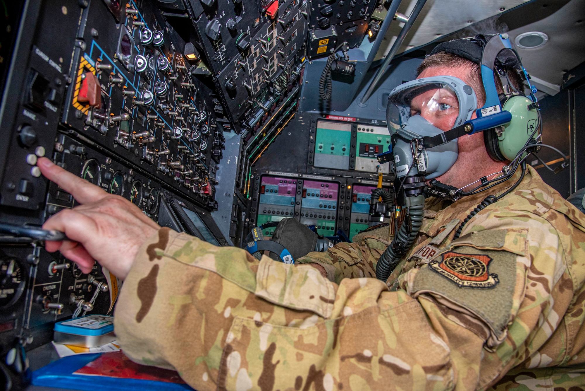 Master Sgt. Jason Carlton, 9th Airlift Squadron flight engineer, completes a pre-flight checklist during a 358 Quick Don Demist oxygen mask test and evaluation at Dover Air Force Base, Delaware, June 14, 2021. Carlton and other aircrew are testing capabilities of the modified masks and providing Air Mobility Command with functional feedback. (U.S. Air Force photo by Tech. Sgt. Nicole Leidholm)