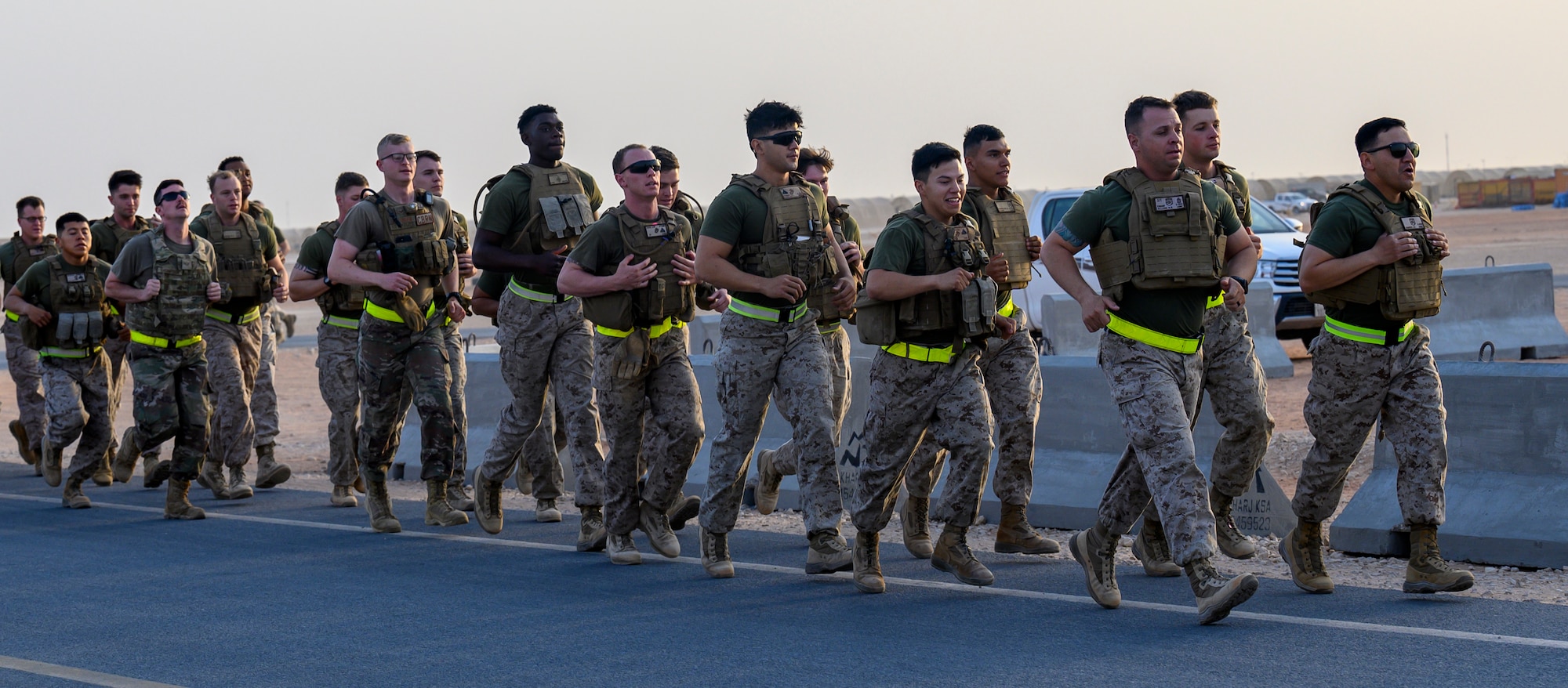 Air Force and Marine Corps personnel run during morning physical training.