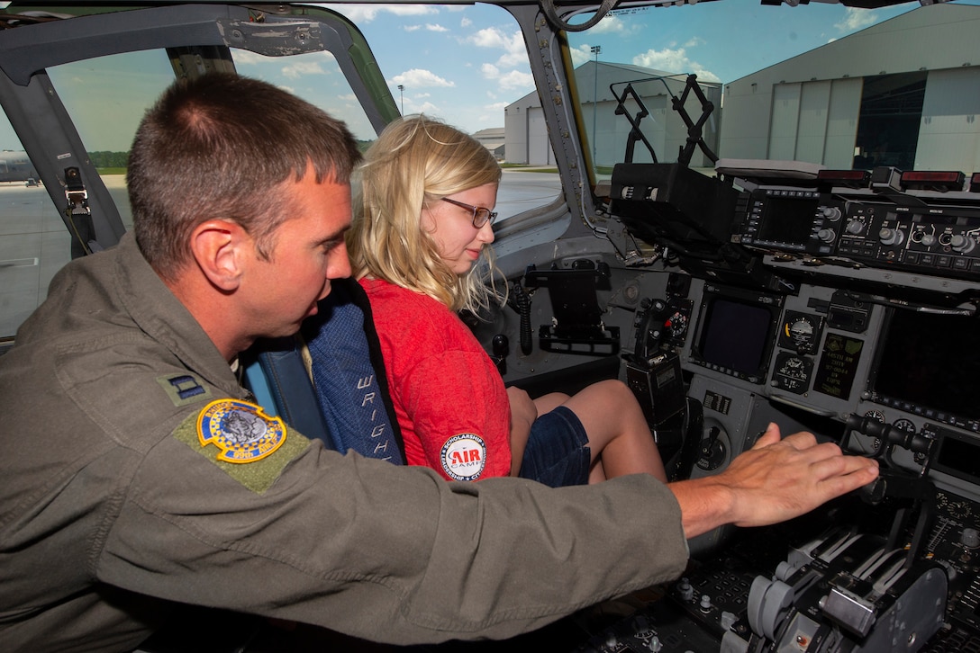 A camper is shown the inside of a C-17 Globemaster III cockpit by Capt. Matthew Bush, 89th Airlift Squadron pilot, at Wright-Patterson Air Force Base, Ohio, on June 14, 2021. Air Camp is a STEM program designed to raise interest in aviation among middle school students. (U.S. Air Force photo by R.J. Oriez)