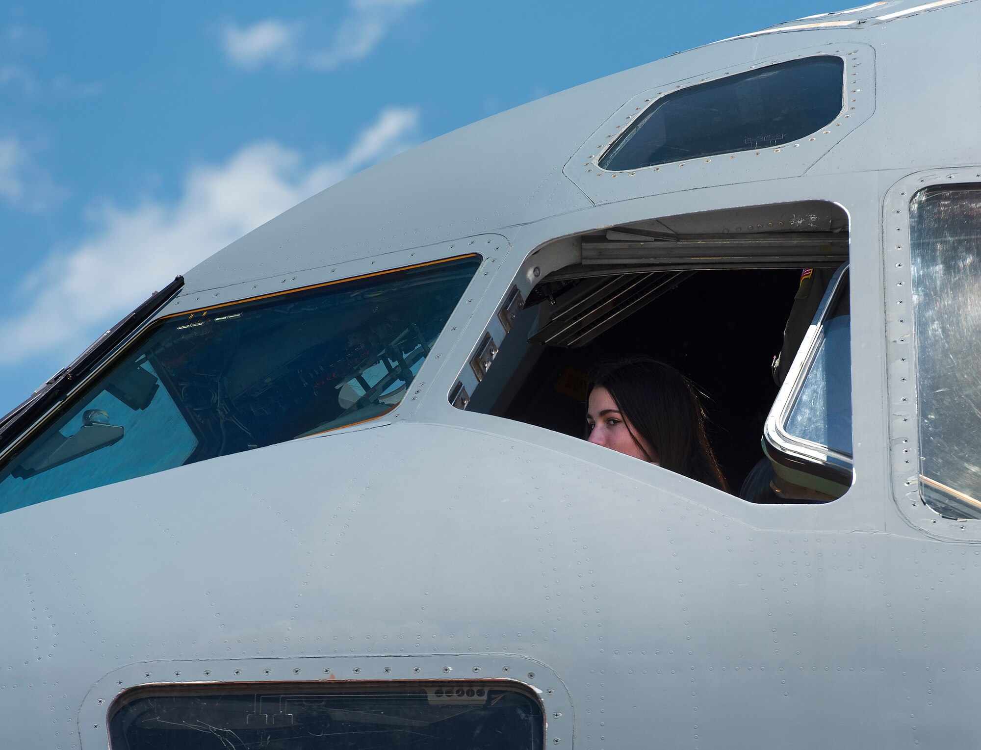 A camper looks out the cockpit window of a C-17 Globemaster III aircraft June 14, 2021, at Wright-Patterson Air Force Base, Ohio. She was taking part in Air Camp, a STEM program set up to raise interest in aviation among middle  school students. (U.S. Air Force photo by R.J. Oriez)