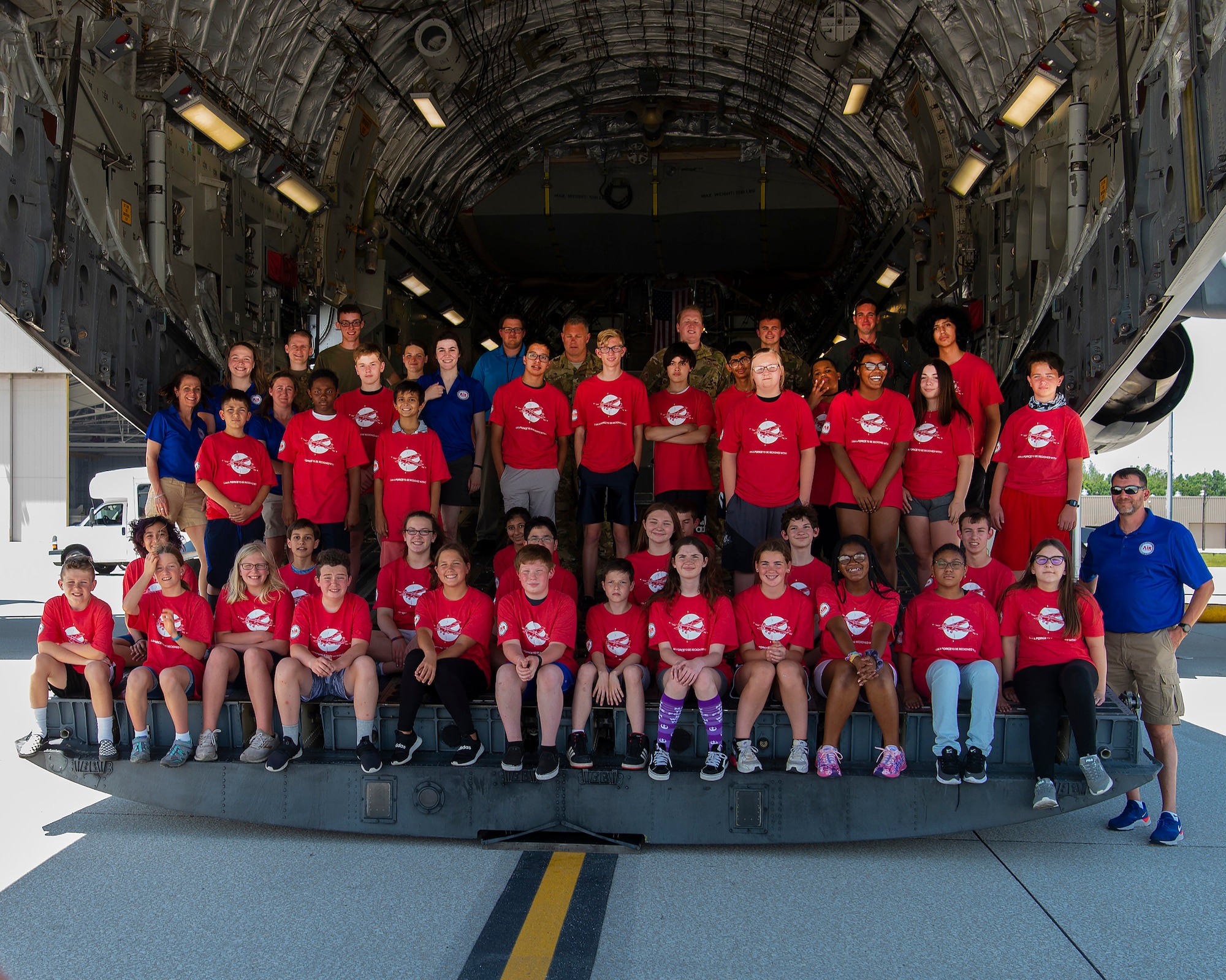 Air Camp attendees and staff pose for a class photo with 445th Airlift Wing members on the ramp of a C-17 Globemaster III at Wright-Patterson Air Force Base, Ohio, on June 14, 2021. Camp participants came to Wright-Patt to tour aircraft, learn about firefighting and visit the U.S. Air Force School of Aerospace Medicine. (U.S. Air Force photo by R.J. Oriez)