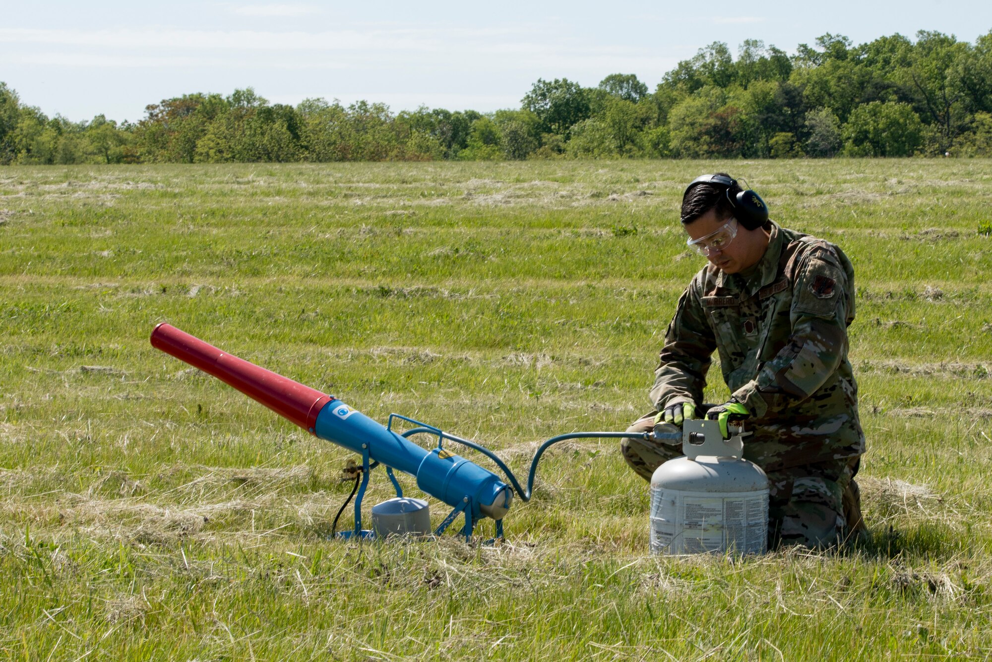 U.S. Air Force Master Sgt. Jose Marrero, noncommissioned officer in charge of airfield management with the 167th Operations Support Group, sets up a pyrotechnic propane canon near the runway, as part of the Bird/wildlife Aircraft Strike Hazards (BASH) program, at the 167th Airlift Wing, Martinsburg, West Virginia, May 12, 2021. The airfield management team uses many different types of noise making devices to encourage animals to move away from the airfield to ensure safe flying operations.
