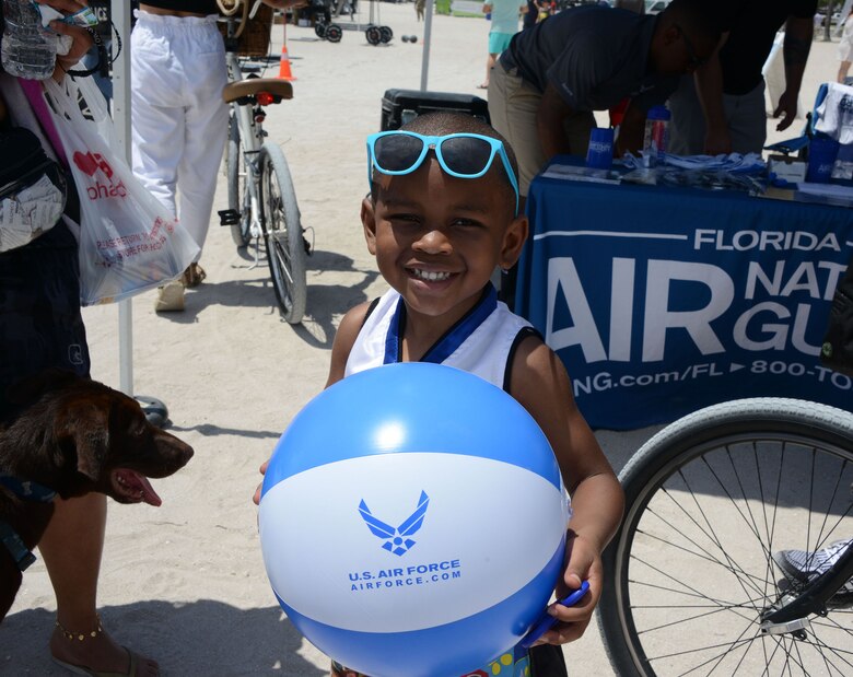 A young aviation enthusiast shows off his Air Force beachball while visiting the Total Force recruiting team at the Miami Beach Air Show, May 28, 2021.