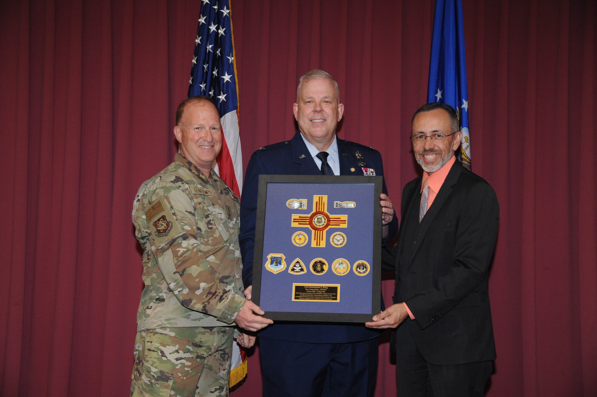 Maj. Gen. Anthony W. Genatempo, Air Force Nuclear Weapons Center commander, left, and Joseph Oder, AFNWC executive director, right, present a framed momento to Col. Christopher J. King, AFNWC vice commander, during his retirement ceremony June 4, 2021, at Kirtland Air Force Base, New Mexico, after 36 years on active duty. King was the center’s vice commander from June 2020 to June 2021. (Air Force photo by Todd Berenger)