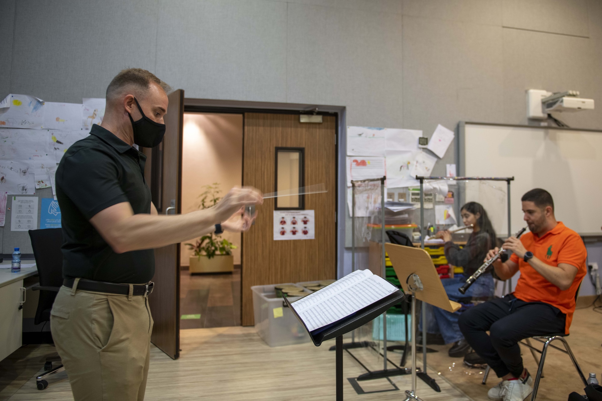 U.S. Air Force 1st Lt. Brandon Hults, AFCENT Band officer in charge, conducts wind players from the Qatar Youth Orchestra at the Qatar Music Academy, June 15, 2021, Doha, Qatar.  Members of the AFCENT Band worked with students during class and played alongside them during rehearsal. The AFCENT Band uses community engagement opportunities like school visits to share the Air Force mission through music. (U.S. Air Force photo by Tech. Sgt. Dylan Nuckolls)