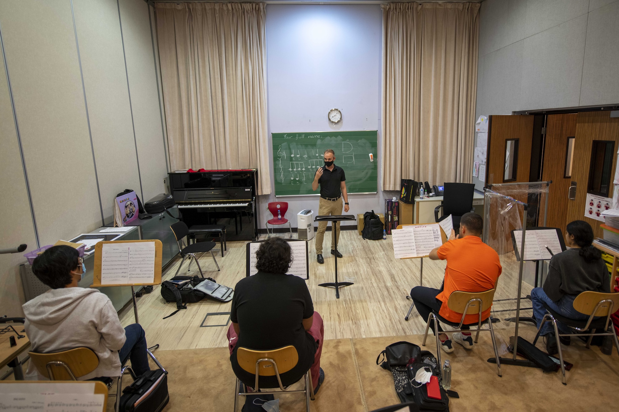 U.S. Air Force 1st Lt. Brandon Hults, AFCENT Band officer in charge, conducts wind players from the Qatar Youth Orchestra at the Qatar Music Academy, June 15, 2021, Doha, Qatar.  Members of the AFCENT Band worked with students during class and played alongside them during rehearsal. The AFCENT Band uses community engagement opportunities like school visits to share the Air Force mission through music. (U.S. Air Force photo by Tech. Sgt. Dylan Nuckolls)