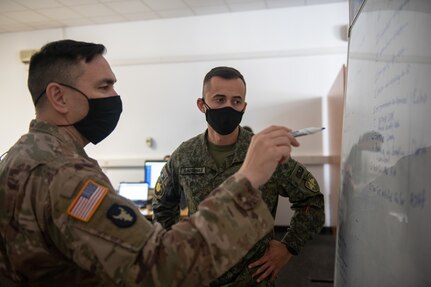 U.S. Army Lt. Col. Gene Harrigan, the defensive cyber operations team chief of the information with Minnesota National Guard Joint Force Headquarters Defensive Cyber Operations Element, explains information to Capt. Genti Koqinaj of the Kosovo Security Forces during a joint cyber training exercise, Midwest Croatia Kosovo Exercise Adriatic Thunder at Dr. Franjo Tudman Croatian Military Academy, Zagreb, Croatia, on June 15, 2021.