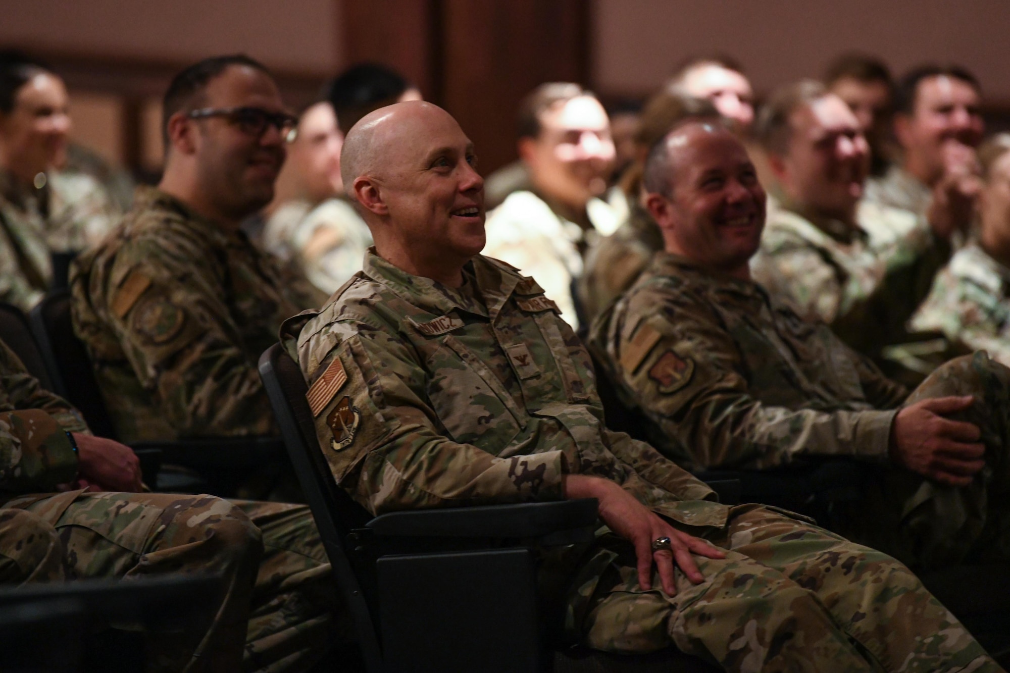 Col. Deane Konowicz, 90th Missile Wing vice commander, watches the "Comedy is the Cure" show performed by Bernie McGrenahan, a stand-up comedian and motivational speaker, to military members for the first time in over 18 months on June 15, 2021, in the base theatre at F.E. Warren Air Force Base, Wyoming. McGrenahan delivers the original comedy with a message, using humor followed by his personal life testimony to demonstrate the negative outcomes of alcohol dependence and the importance of staying resilient.