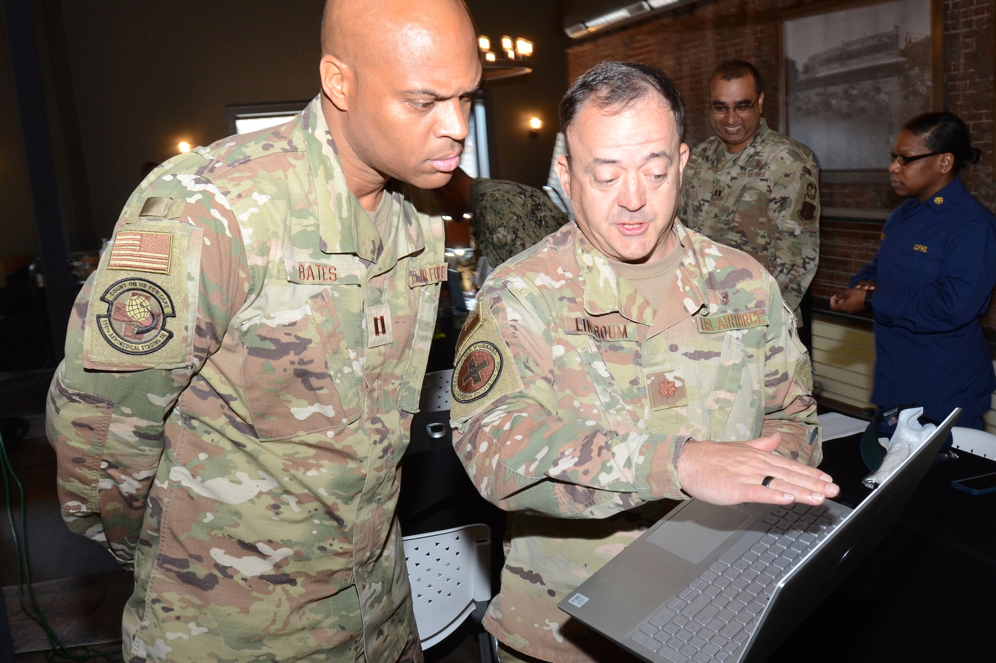 U.S. Air Force Maj. Dan Linkroum (right), a medical operations officer assigned to the 169th Fighter Wing, McEntire Joint National Guard Base, South Carolina, supports Operation Healthy Delta, a Department of Defense sponsored Innovative Readiness Training program designed to provide military training opportunities by providing key services to local citizens. Linkroum briefs U.S. Air Force Capt. Bates in the operation command center in  Sikeston, Missouri June 15, 2021. (U.S. Air National Guard photo by Lt. Col. Jim St.Clair, 169th Fighter Wing Public Affairs)