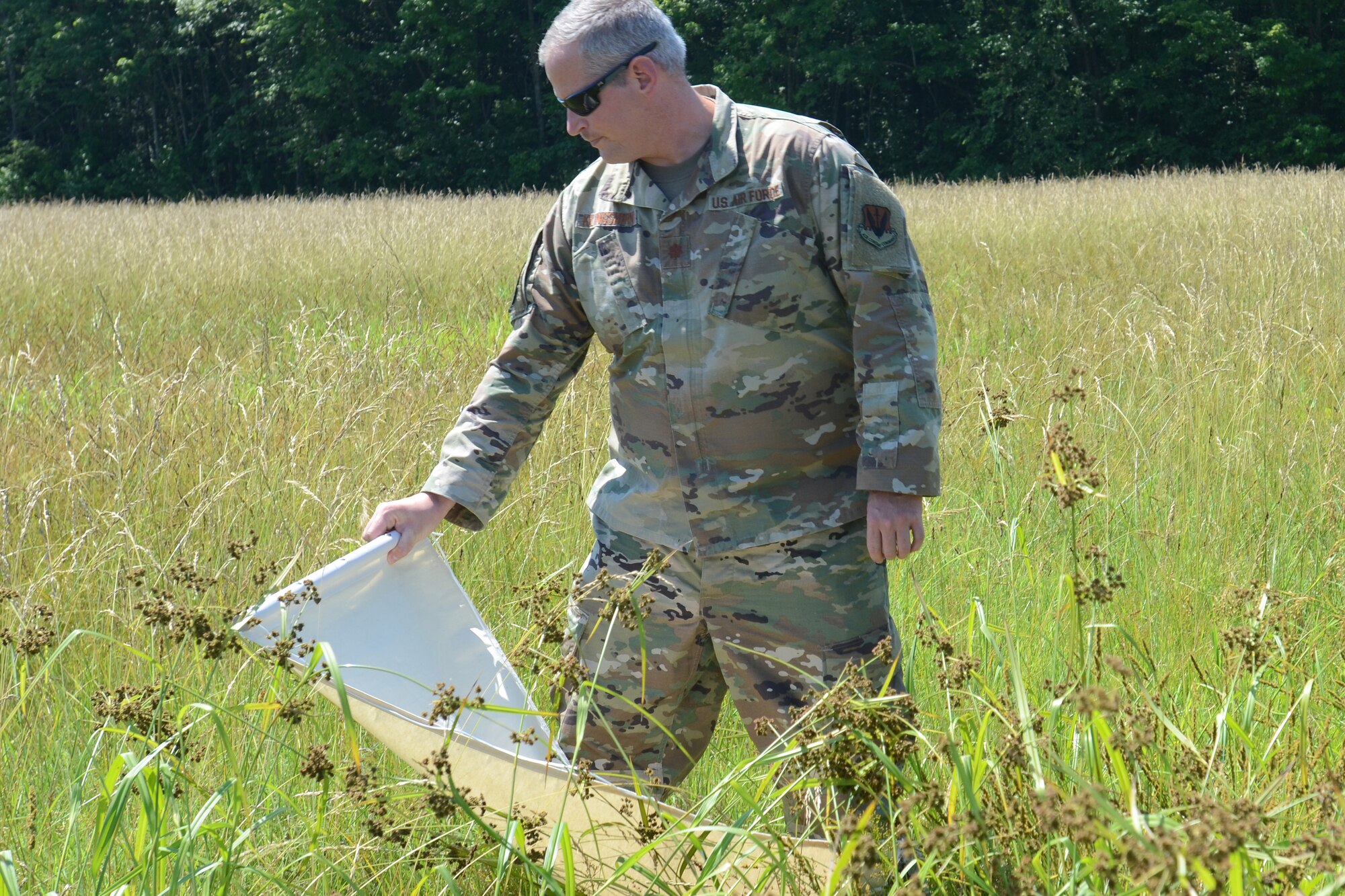 U.S. Air Force Maj. Mike Klingshirn, assigned to the 169th Fighter Wing, McEntire Joint National Guard Base, South Carolina, supports Operation Healthy Delta, a Department of Defense sponsored Innovative Readiness Training program designed to provide military training opportunities by providing key services to local citizens. Klingshirn is conducting a tick drag for vector control at Massac County High School, Metropolis, Illinois June 16, 2021. (U.S. Air National Guard photo by Lt. Col. Jim St.Clair, 169th Fighter Wing Public Affairs)