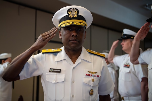 Rear Adm. Brad Collins, new commander, Navy Region Northwest relieves Rear Adm. Stephen Barnett, outgoing commander during a change of command ceremony at Naval Base Kitsap-Bangor June 18.