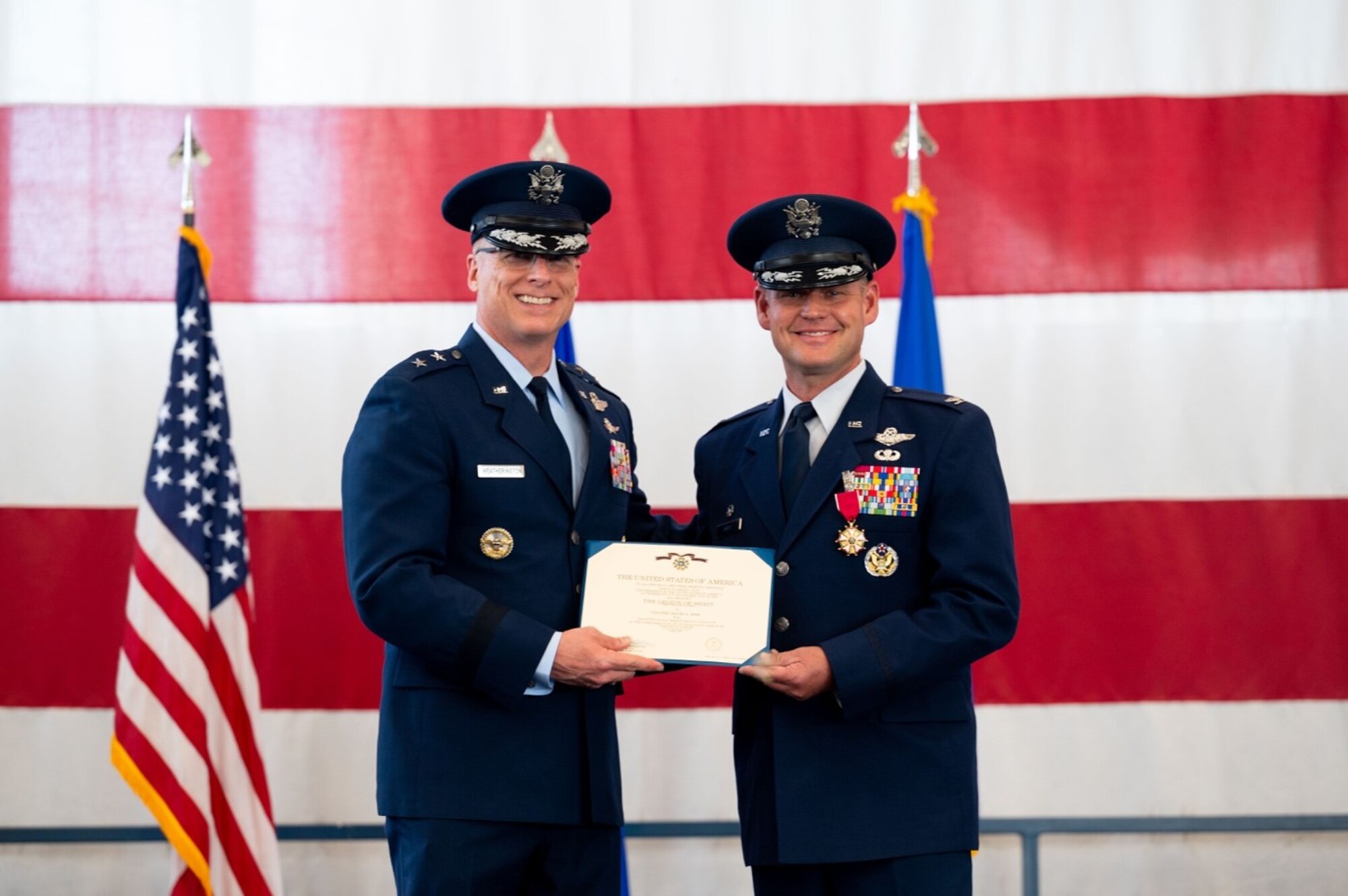 Maj. Gen. Mark E. Weatherington, 8th Air Force and Joint-Global Strike Operations Center commander, presents Col. David A. Doss, the outgoing 28th Bomb Wing commander, with the Legion of Merit during the 28th BW change of command ceremony at Ellsworth Air Force Base, S.D., June 18, 2021.