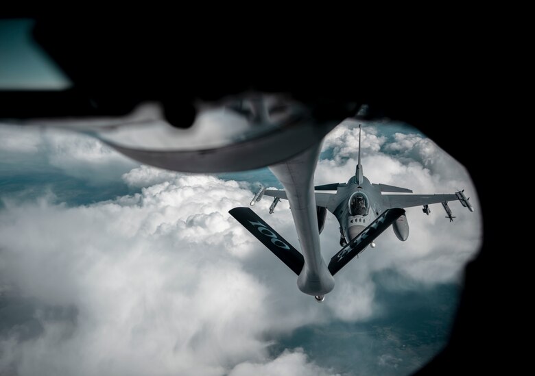 A U.S. Air Force KC-135 Stratotanker aircraft assigned to the 100th Air Refueling Wing at Royal Air Force Mildenhall, England, provides fuel to an F-16 Fighting Falcon aircraft assigned to the 52d Fighter Wing, Spangdahlem Air Base, Germany, for the Arctic Challenge Exercise above Sweden, June 15, 2021. Agile combat employment exercises enable the 100th ARW to become more agile and responsive to better support European partners and allies. (U.S. Air Force photo by Senior Airman Antonia Herrera)