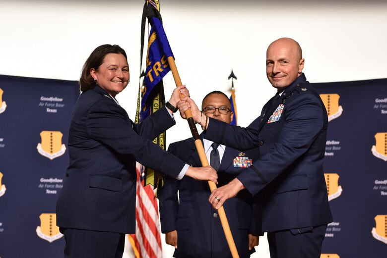 U.S. Air Force Col. Angelina Maguinness, 17th Training Group commander, takes the guidon from Lt. Col. Christopher Sharp, outgoing 316th Training Squadron commander, during the change of command ceremony at the Base Theater on Goodfellow Air Force Base, Texas, June 18, 2021. Sharp is retiring from the Air Force after 27 years of active duty. (U.S. Air Force photo by 2nd Lt. Steve Garrett)