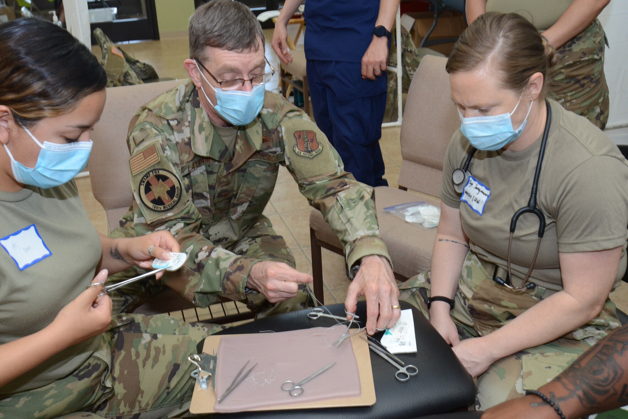 U.S. Air Force Col. (Dr.) Phillip Latham, assigned to the 169th Fighter Wing, McEntire Joint National Guard Base, South Carolina, supports Operation Healthy Delta, a Department of Defense sponsored Innovative Readiness Training program designed to provide military training opportunities by providing key services to local citizens. Latham is practicing suturing with Airmen from the 162nd Wing Tucson Arizona during a break in the action at Sikeston, Missouri June 15, 2021. (U.S. Air National Guard photo by Lt. Col. Jim St.Clair, 169th Fighter Wing Public Affairs)