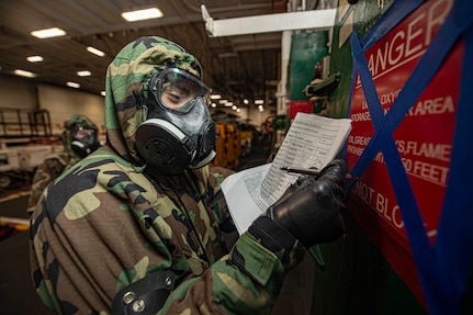 Aviation Electronics Technician 3rd Class Michael Tofalo, from Boston, records the status of a simulated casualty indicator during a general quarters training evolution in the hangar bay of the Nimitz-class aircraft carrier USS Harry S. Truman (CVN 75) during Tailored Ship's Training Availability (TSTA) and Final Evaluation Problem (FEP).