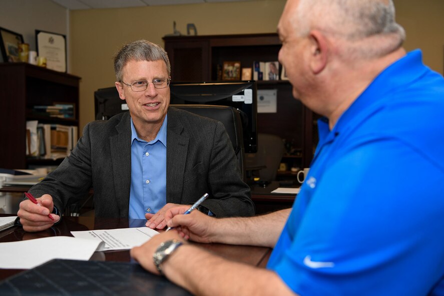 Mike Giger, site senior functional for Acquisition - Operating Location Hanscom, reviews charts with Randy Hatem, operations manager, June 15, at Hanscom Air Force Base, Mass.