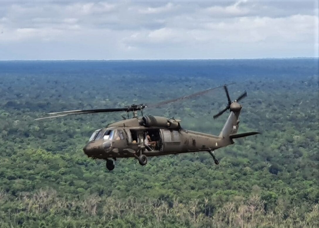 A UH-60 Blackhawk flies over the jungles of Guyana.