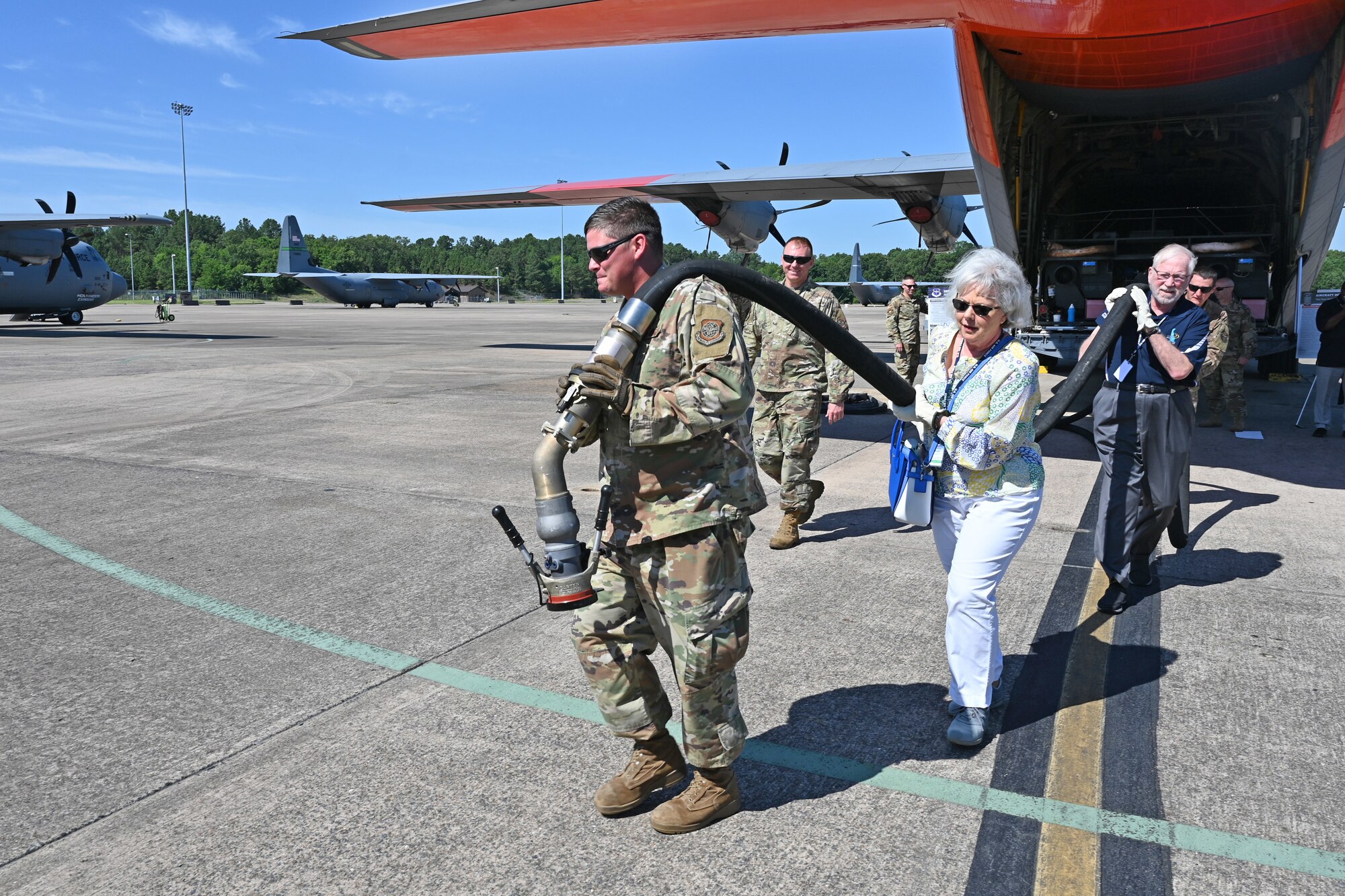Air Mobility Command Civic Leaders carry a fuel truck hose