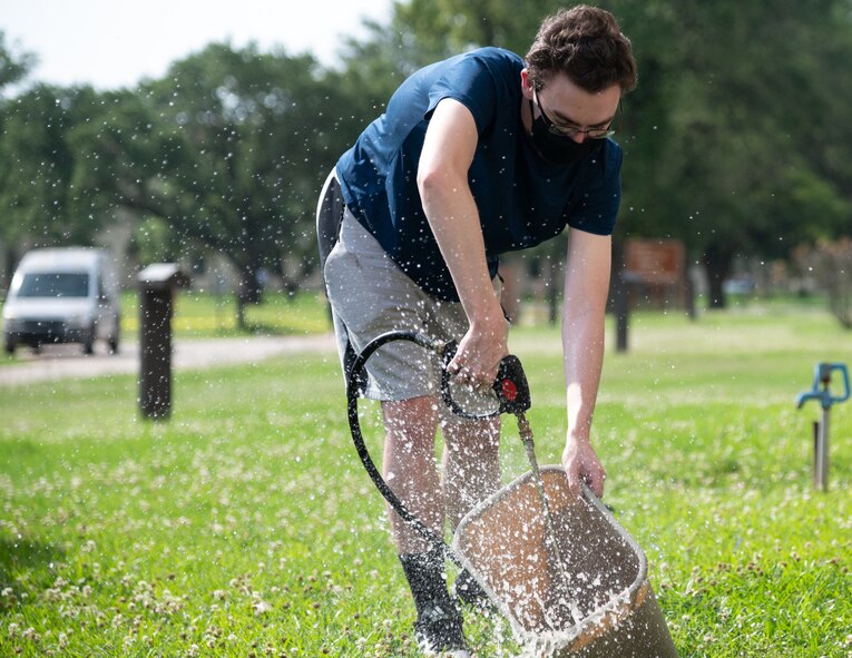 An Airman cleans a trash can during a campus clean-up at Barksdale Air Force Base, Louisiana, June 12, 2021. The clean-up efforts provided dorm residents the opportunity to learn from and connect with their senior leadership. (U.S. Air Force photo by Airman 1st Class William Pugh)