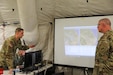U.S. Army Reserve Spc. Zachary H. Bendorf, psychological operations specialist, 11th Psychological Operations Battalion, briefs Brig. Gen. Jeffrey C. Coggin, commanding general, U.S. Army Civil Affairs and Psychological Operations Command (Airborne), using the Command Post of the Future (CPOF) platform. Bendorf is able to brief the commanding general on battlefield topsight, collaboration and live data using this system at Command Post Exercise – Functional (CPX-F) at Fort McCoy, Wis., June 10, 2021.