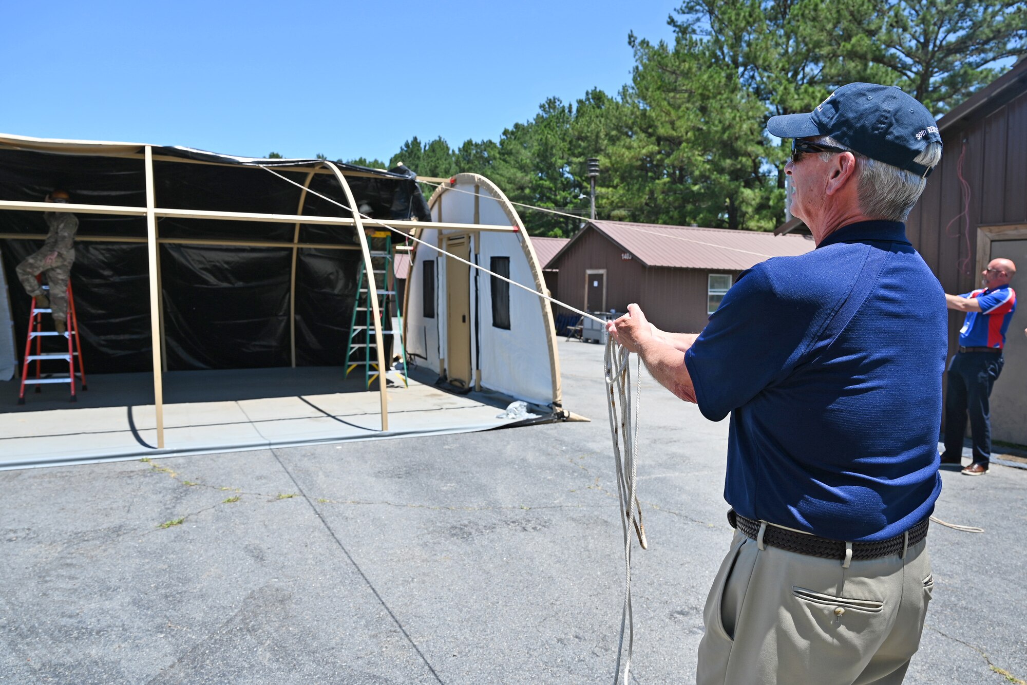 Kevin Twohig, Air Mobility Command Civic Leader representing Fairchild Air Force Base, Washington, helps configure a military shelter system